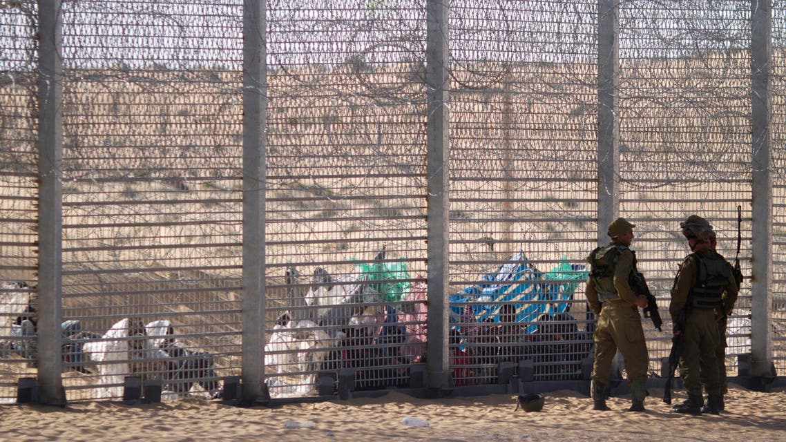 a border fence after they attempted to cross illegally from Egypt into Israel as Israeli soldiers stand guard near the border with Egypt, in southern Israel.