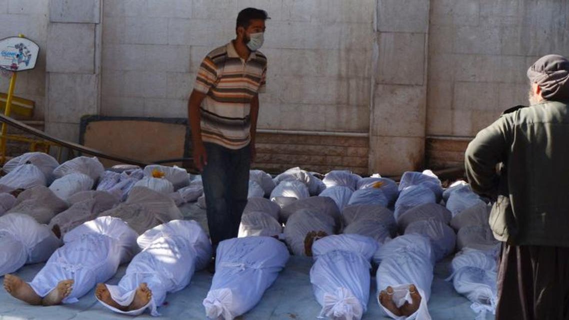 Syrian activists inspect the bodies of people they say were killed by nerve gas in the Ghouta region. (Reuters)