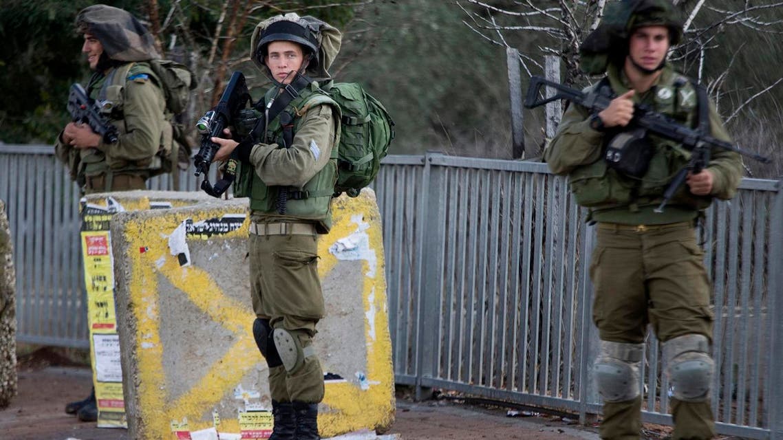 Israeli soldiers stand guard at a bus stop after near the Palestinian town of Nablus in the occupied West Bank. (File photo: AP)