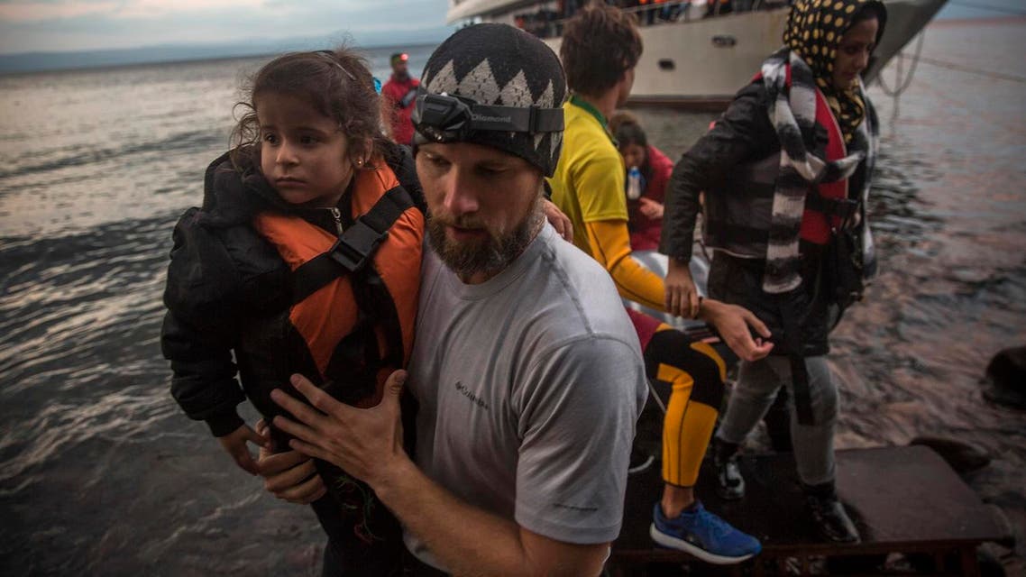 Volunteers assist refugees to disembark from a yacht, on which around 250 people crossed a part of the Aegean sea from Turkey's coast to the Greek island of Lesbos. (File photo: AP)