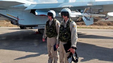 Russian pilots stand outside their Su-30 jet fighter, armed with air-to-air missiles, before a take off at Hmeimim airbase in Syria. (File photo: AP)