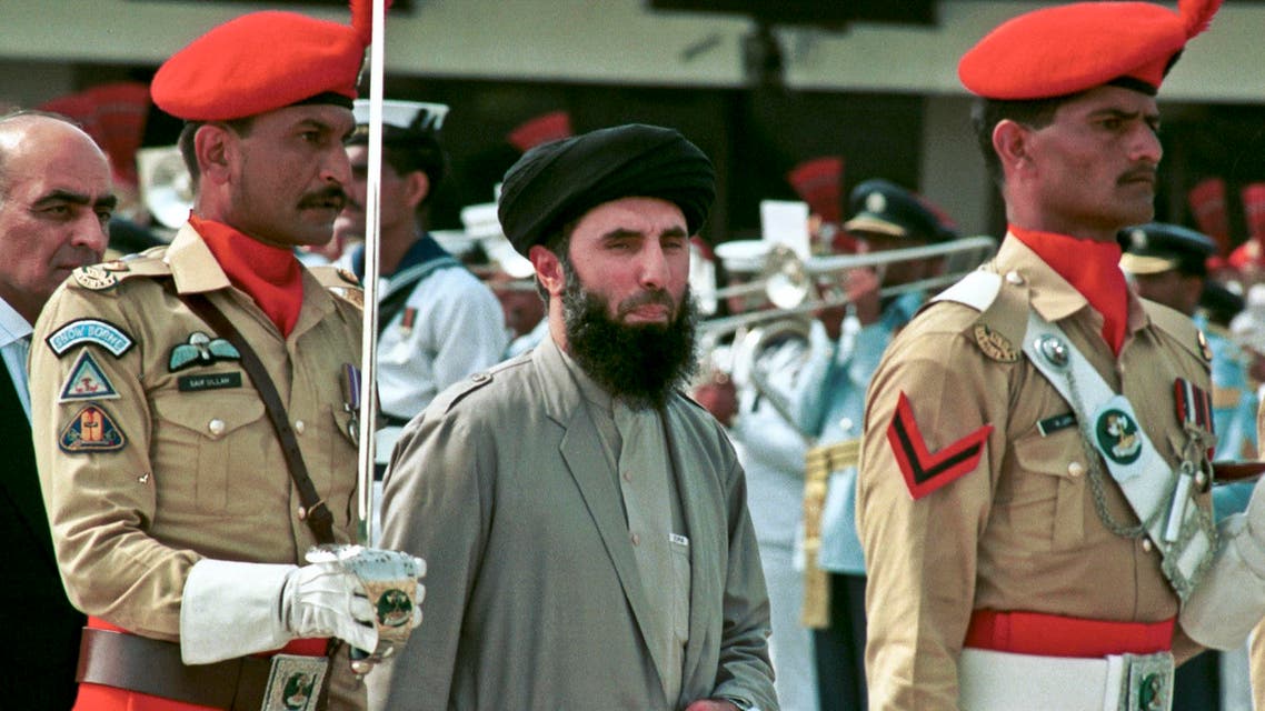 In this Wednesday, June 26, 1996 file photo, Gulbuddin Hekmatyar, center, passes in front of an honor guard in the Afghan capital of Kabul, Afghanistan.