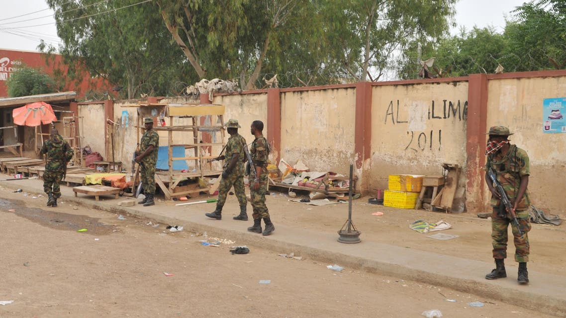 Soldiers stand guards at the scene of an explosion at a market in Kano, Nigeria. Wednesday Nov. 18, 2015. (AP)
