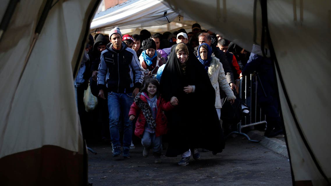 Migrants walk into a tent to register with the police at a refugee center in the southern Serbian town of Presevo, Monday, Nov. 16, 2015.