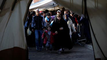 Migrants walk into a tent to register with the police at a refugee center in the southern Serbian town of Presevo, Monday, Nov. 16, 2015.