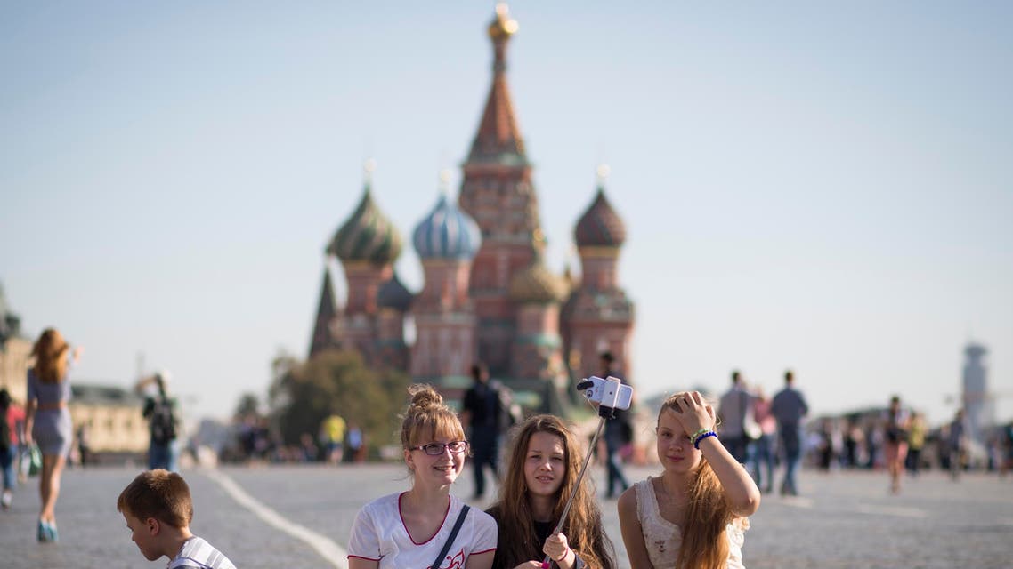 A group of tourists poses for a selfie at Red Square with the St. Basil's Cathedral in the background in Moscow, Russia, Friday, Sept. 25, 2015. (AP)