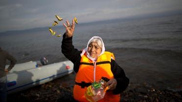 An elderly refugee throws candy in the air shortly after she and other crossed the Aegean sea on a dinghy from the Turkish coast to the Greek island of Lesbos, Tuesday, Nov. 24, 2015. (Reuters)