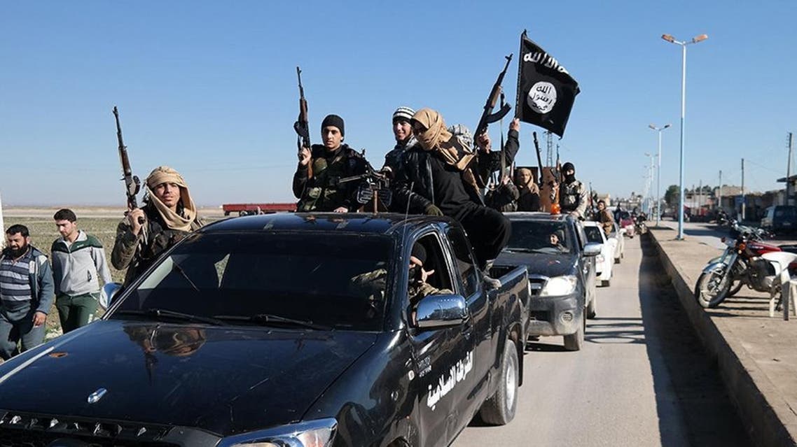 Islamic State militants pass by a convoy in Tel Abyad town, northeast Syria, May 4, 2015 | AP