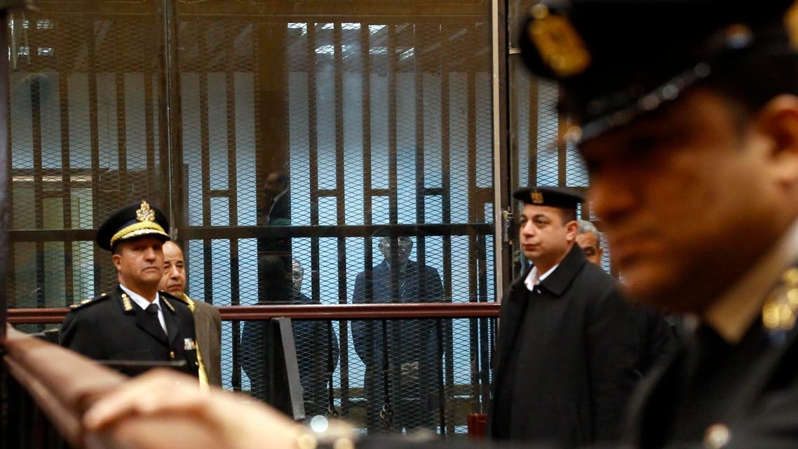 Former Egyptian Prime Minister Ahmed Nazif, right in cage, and former Interior Minister Habib el-Adly, stand behind bars in a courtroom during a retrial hearing that acquitted them over charges of squandering public money in Cairo, Egypt, Tuesday, Feb. 24, 2015. The case stems from allegations they collaborated in awarding a German firm a contract to import license plates by direct order. Over the past months, many Mubarak-era officials have won a series of acquittals, mostly in corruption-related cases. (AP Photo/El Shorouk, Aly Hazzaa) EGYPT OUT