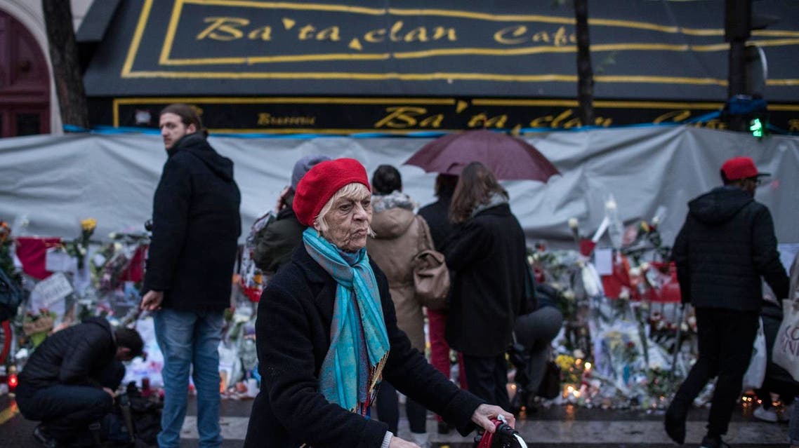 A woman walks as people pay respects to victims of the Paris attacks in front of the Bataclan concert hall on Nov. 25, 2015, in Paris. (AP)