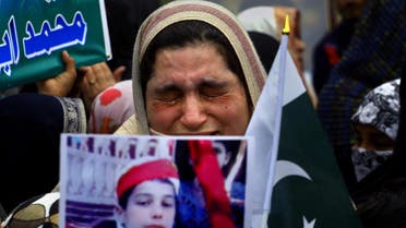A mother weeps as she carries a picture of her slain son during a tribute to students who were killed in an attack on a school last year by Taliban gunmen, in Peshawar, Pakistan. (File photo: AP)