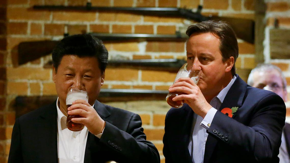 Britain's Prime Minister David Cameron, right, drinks beer with Chinese President Xi Jinping, at a pub in Princess Risborough, near Chequers, England, Thursday, Oct. 22, 2015. The two leaders met for talks and dinner at the prime minister’s official country residence Thursday, during a state visit hailed as a landmark by both China and Britain. (AP Photo/Kirsty Wigglesworth, pool)