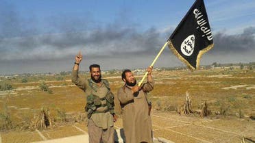  FILE - In this file photo released on Sunday, June 28, 2015, by a website of Islamic State militants, an Islamic State militant waves his group's flag as he and another celebrate in Fallujah, Iraq, west of Baghdad.The Islamic State’s gruesome rampage across the Middle East has united the world in horror but left it divided over how to refer to the group, with observers adopting different acronyms based on their translation of an archaic geographical term and the extent to which they want to needle the group. (Militant website via AP, File)