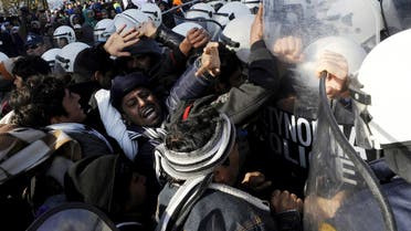 Stranded migrants scuffle with Greek police officers as they try to cross the Greek-Macedonian border, near the village of Idomeni, Greece December 2, 2015. 