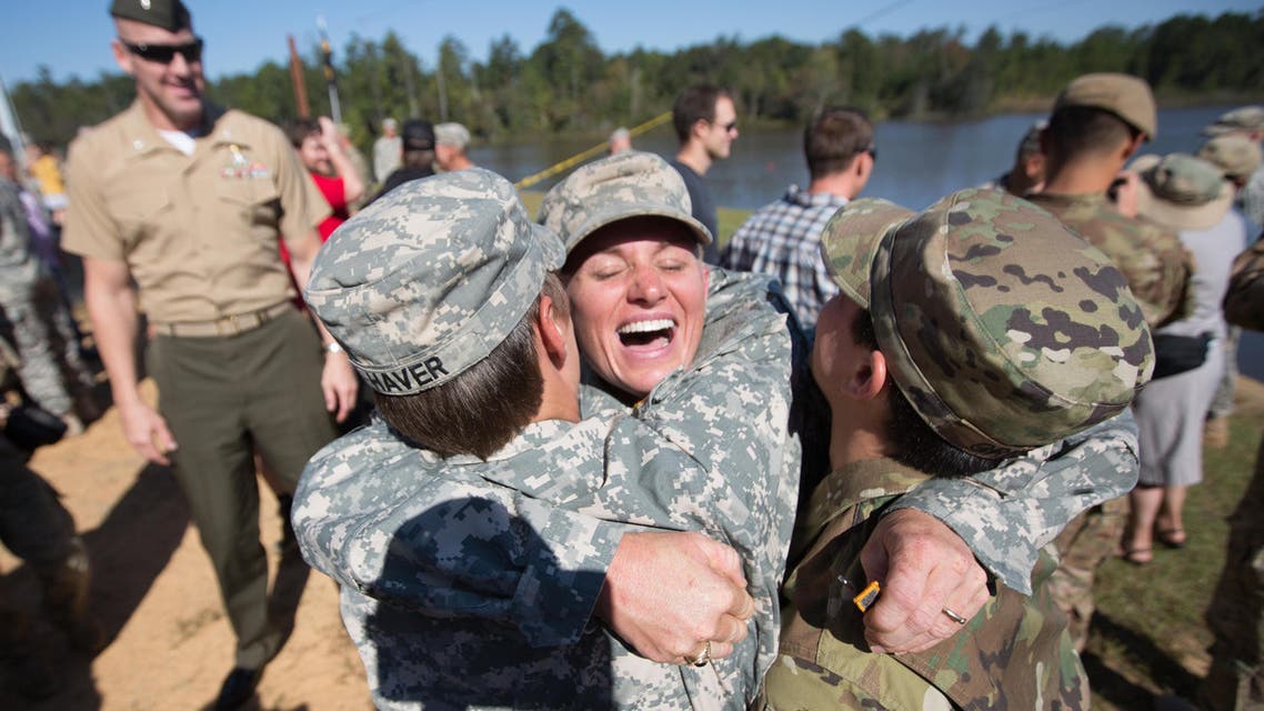 Maj. Lisa Jaster, center, embraces First Lt. Shaye Haver, left, and U.S. Army Capt. Kristen Griest, right, after an Army Ranger School graduation ceremony, Friday, Oct. 16, 2015, in Fort Benning, Ga. Jaster, who is the first Army Reserve female to graduate the Army's Ranger School, joins Griest and Haver as the third female soldier to complete the school. (AP Photo/Branden Camp)