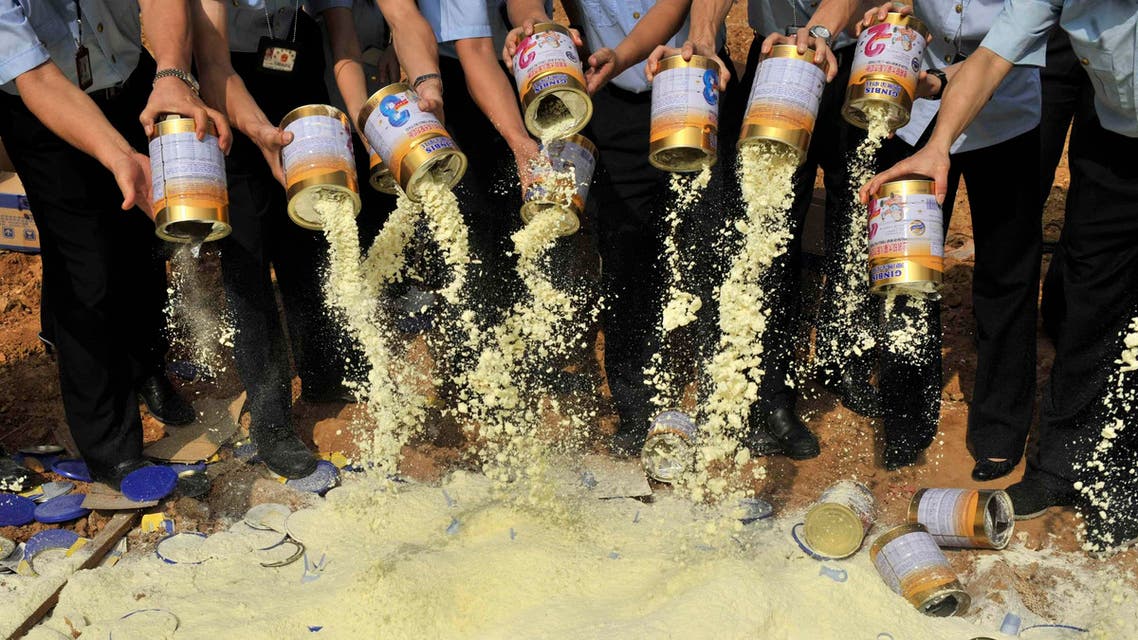 Staff members of the local quality supervision bureau empty tainted milk powder packets at a garbage dump site in Shenzhen, Guangdong province September 19, 2008. (Reuters)