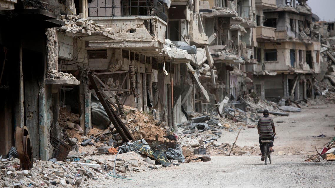 FILE - In this June 5, 2014, file photo, a man rides a bicycle through a devastated part of Homs, Syria. From the three-year-old boy who washed ashore on a Turkish beach to the 71 migrants who suffocated in a truck in Austria to the daily scenes of chaos unfolding in European cities as governments try to halt a human tide heading north. There is no let up to the horrors that Syria’s civil war keeps producing. Syria’s brutal conflict, now in its fifth year, has touched off the greatest humanitarian crisis of our time. About 250,000 people have been killed and more than one million wounded since March 2011, according to U.N. officials. (AP Photo/Dusan Vranic, File)