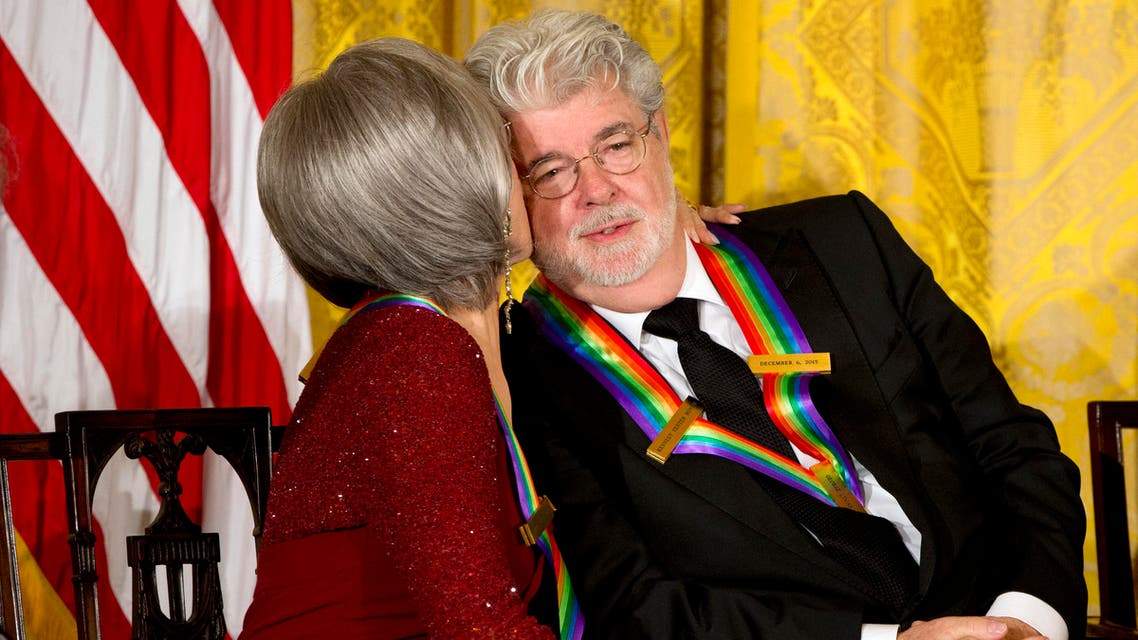 Actress and singer Rita Moreno, left, kisses filmmaker George Lucas on the cheek, as the 2015 Kennedy Center Honors honorees listen to President Barack Obama speak at the 2015 Kennedy Center Honors reception in the East Room of the White House in Washington, Sunday, Dec. 6, 2015. (AP)