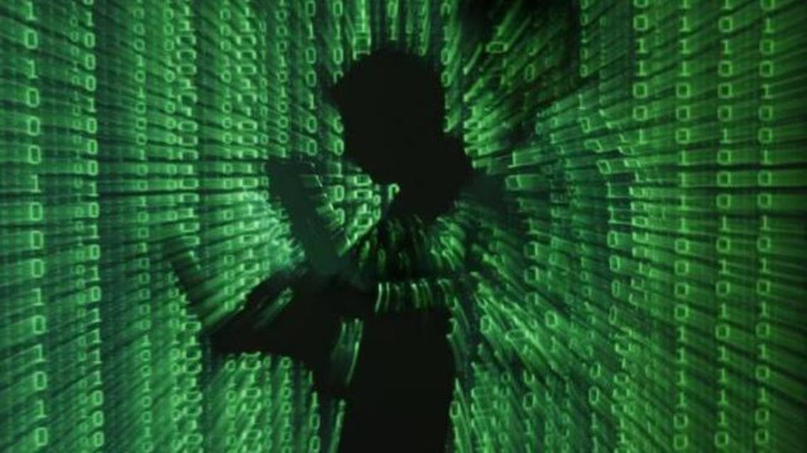 An illustration picture shows a projection of binary code on a man holding a laptop computer, in an office in Warsaw June 24, 2013. (Reuters)