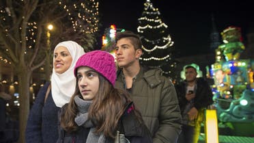 In this photo taken Tuesday, Dec. 8, 2015, Syrian refugees Reem Habashieh, Raghad Habashieh, Yaman Habashieh and Mohammed Habashieh, from left to right, visit the Christmas market in Zwickau, eastern Germany.