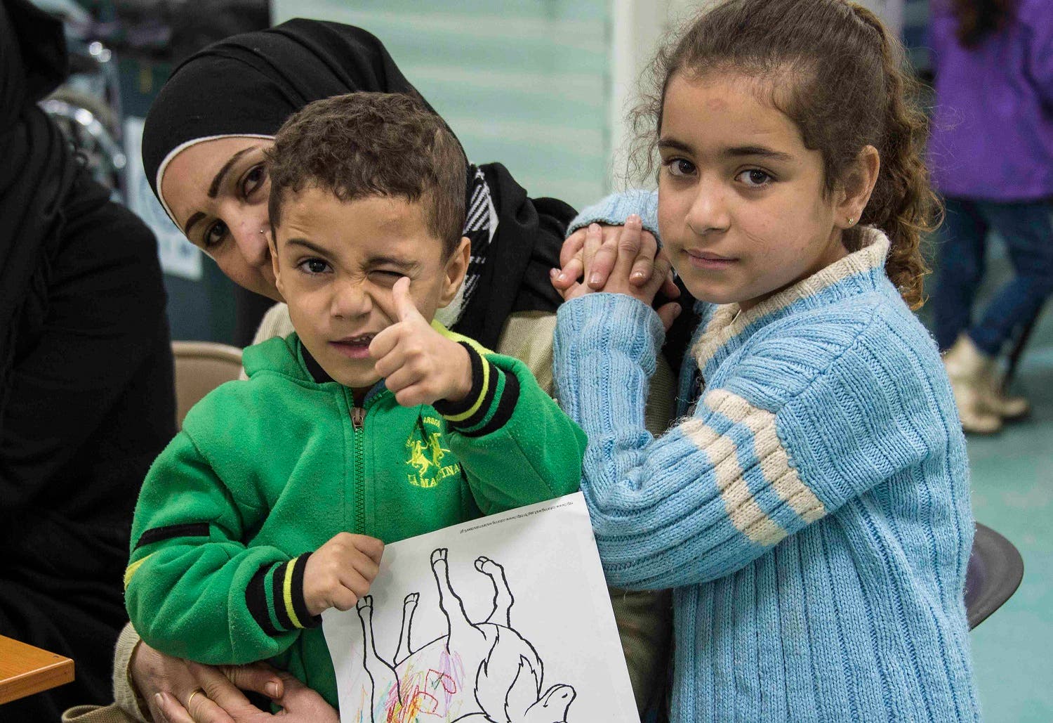 Two Syrian refugee children pose while their family undergoes medical screening before the beginning of an airlift to Canada, in Beirut. (Reuters)