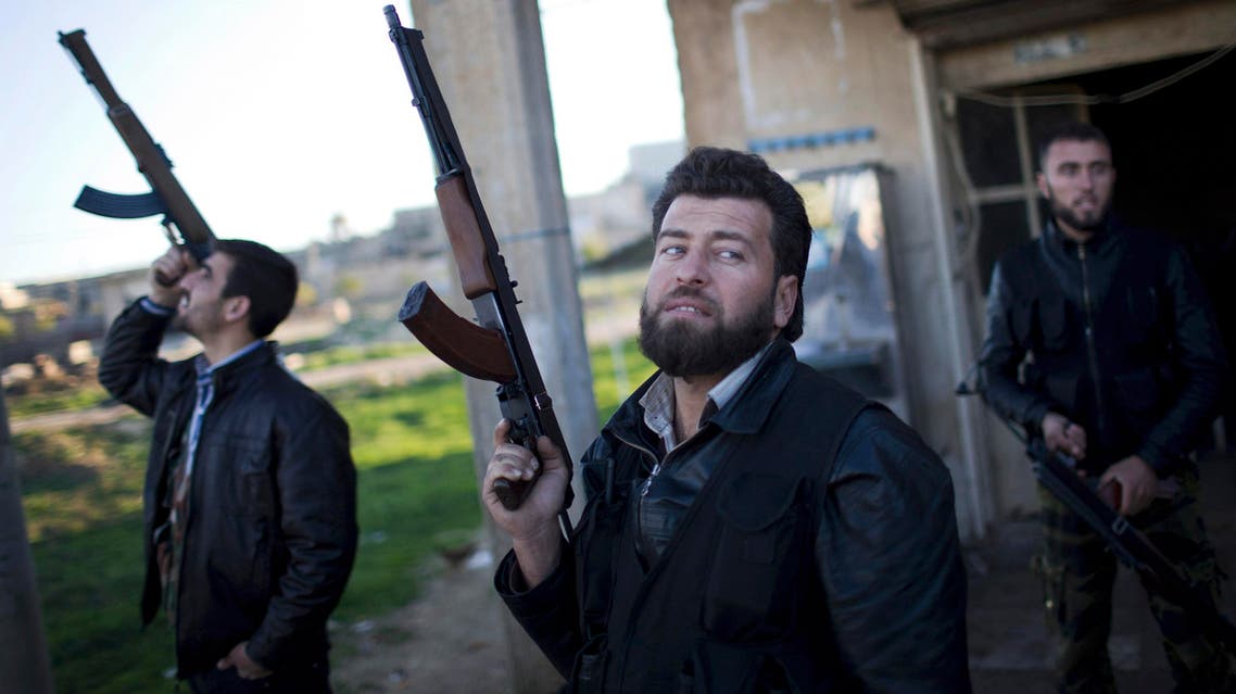 In this Tuesday, Dec. 11, 2012 file photo, Free Syrian Army fighters look at a Syrian Army jet, not pictured, in Fafeen village, north of Aleppo province, Syria. (AP)