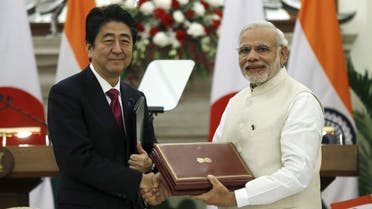 Japan's Prime Minister Shinzo Abe (L) and his Indian counterpart Narendra Modi shake hands while exchanging documents during a signing of agreement at Hyderabad House in New Delhi, India, December 12, 2015.