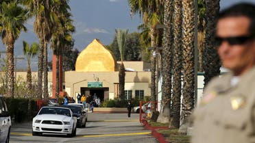 A police officer stands watch as people leave Friday prayers at the Dar Al Uloom Al Islamiyah-Amer mosque where shooting suspect Syed Rizwan Farook was seen two to three times a week at lunch time, in San Bernardino, California December 4, 2015. 