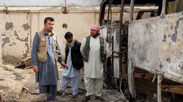 In this Tuesday, Oct. 13, 2015, photo, Afghan businessman Abdul Maroof, left, stands in his warehouse damaged from fighting, in Kunduz, Afghanistan. (AP)