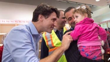 رئيس الوزراء الكندي يداعب طفلة لاجئ سوري