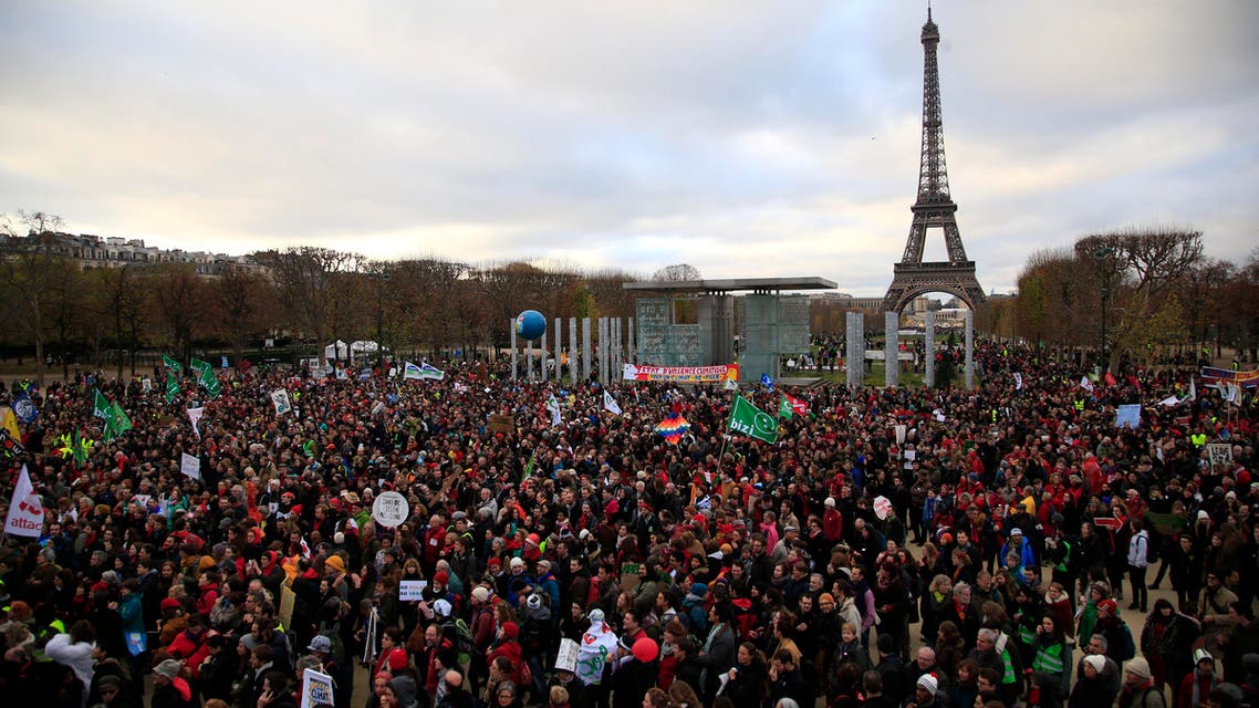 Activists gather near the Eiffel Tower, in Paris, Saturday, Dec.12, 2015 during the COP21, the United Nations Climate Change Conference. As organizers of the Paris climate talks presented what they hope is a final draft of the accord, protesters from environmental and human rights groups gather to call attention to populations threatened by rising seas and increasing droughts and floods. (AP)