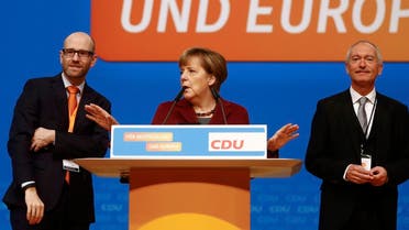 Germany's CDU secretary general Tauber stands on stage with Chancellor Merkel and CDU managing director Schueler as they tour the venue in Karlsruhe. (Reuters)