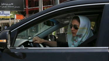 A woman drives in front of an advertising billboard for Bulgari watches in northern Tehran, Iran, Saturday, July 18, 2015. (AP)