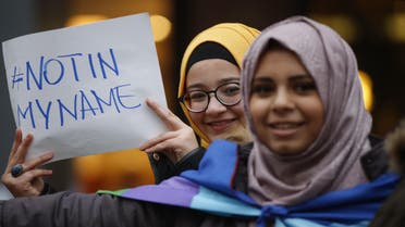 Two girls hold a sign reading "Not in my name" as members of the Milanese Muslim community gather in downtown Milan, Italy, Saturday, Nov. 21, 2015 to protest against violence. (AP Photo/Luca Bruno)