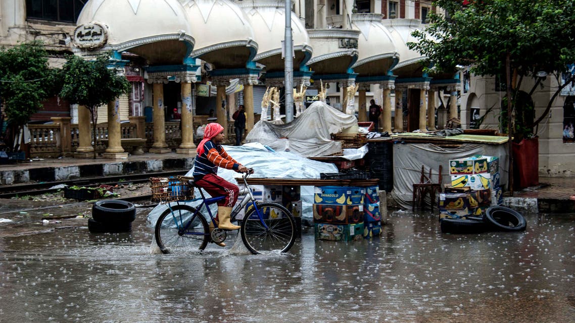 A girl rides a bike during a rain and hail storm, in Alexandria, Egypt, Wednesday, Nov. 4, 2015. (AP)