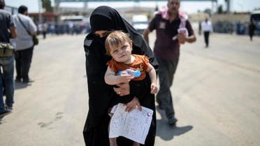 A Syrian woman and her baby arrive in Turkey via the Akcakale border crossing on June 15, 2015; Syria ended visa-free travel by Turks December 17, after Turkey imposed similar restrictions -- though refugees and asylum seekers remain exempt (AFP)
