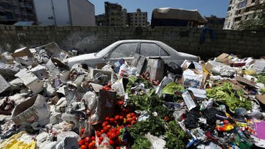 A car is seen between a pile of garbage covered with white pesticide in the Palestinian refugee camp of Sabra in Beirut, Lebanon, Thursday, July 23, 2015. (AP)