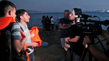 FILE - In this early Tuesday, Aug. 18, 2015 file photo, freelance translator Mohammed Rasool, centre, working for the Associated Press, interviews refugees ready to board a dinghy to try to cross from near the coastal town of Bodrum Turkey, to the nearby Greek island of Kos. Rasool, a 24-year-old Iraqi Kurd who has worked as a fixer for The Associated Press, was helping two Vice News reporters covering clashes between the PKK’s youth group and police. He was arrested on Aug. 27 and remains in a maximum security prison in Turkey. Vice Media is carrying out a two-hour blackout on its websites to call attention to an Iraqi Kurdish journalist who has been held in Turkish jails without charges since being arrested while working for the news organization.(AP Photo)