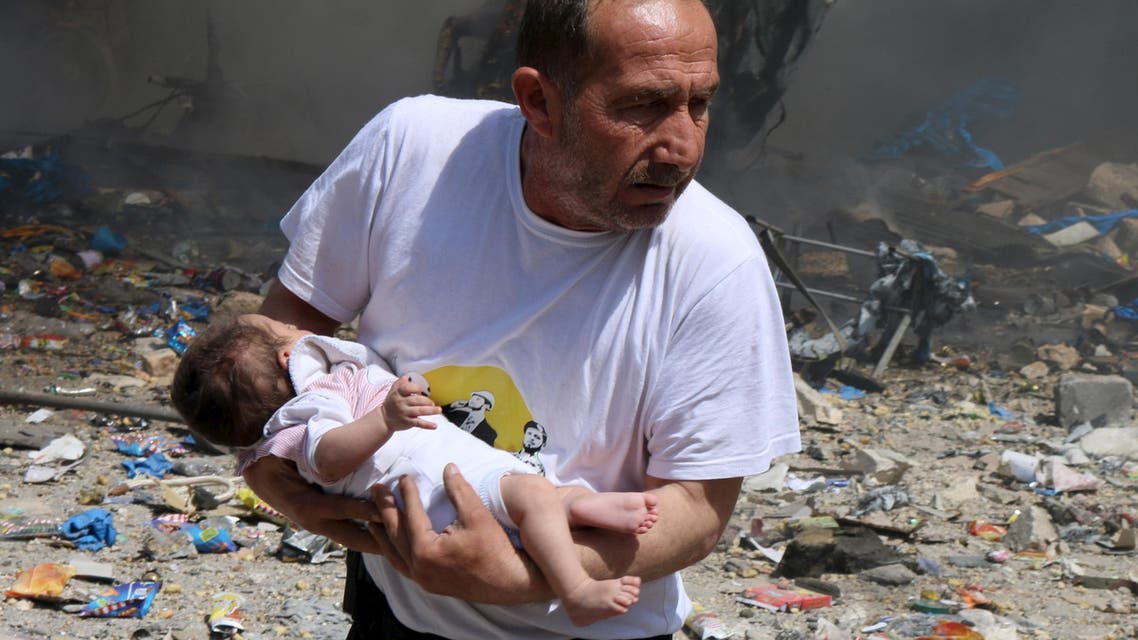 A man holds a baby that survived what activists said was a site hit by a barrel bomb dropped by forces loyal to Syrian President Bashar al-Assad at the old city of Aleppo June 3, 2015. (Reuters)