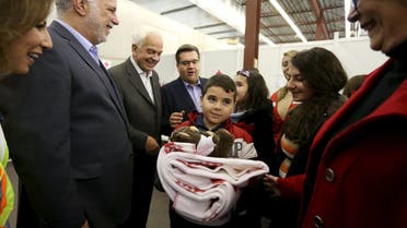 A Syrian refugee family is greeted by Quebec Premier Philippe Couillard (2nd L), Canada's Immigration Minister John McCallum (3rd L) and Montreal Mayor Denis Coderre (C) at the Welcome Centre in Montreal, Quebec, December 12, 2015. REUTERS