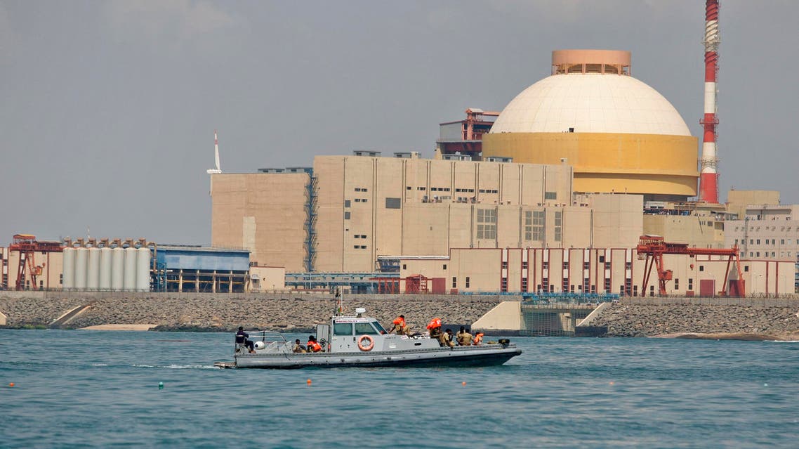 Indian coast guards ride on a boat near the Russian-built Kudankulam Atomic Power Project, background,