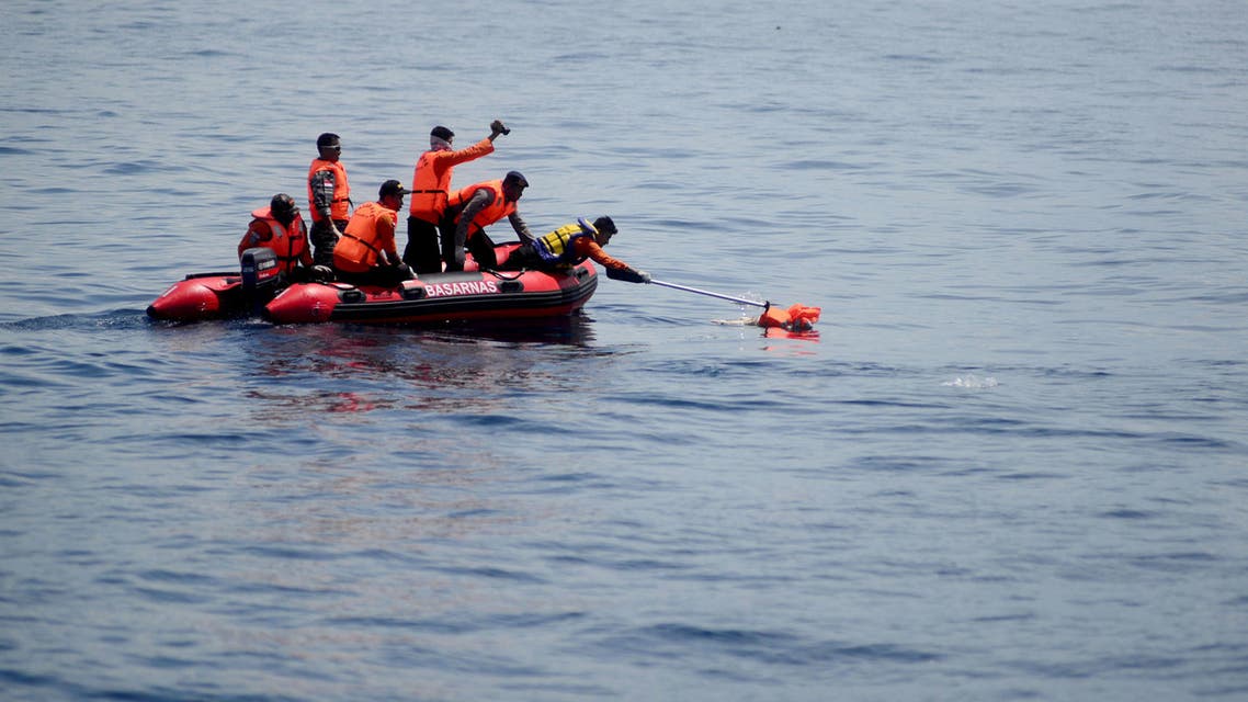 Indonesian search and rescue team members gather the dead body of a baby during an operation in the Sulawesi sea, near Kolaka city on December 24, 2015.