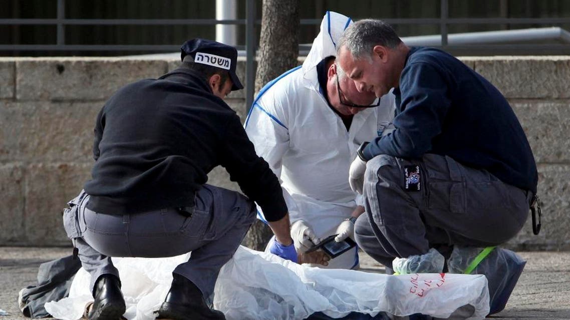 Israeli policemen inspect the body of an alleged Palestinian assailant in Jerusalem Saturday, Dec. 26, 2015 | AP