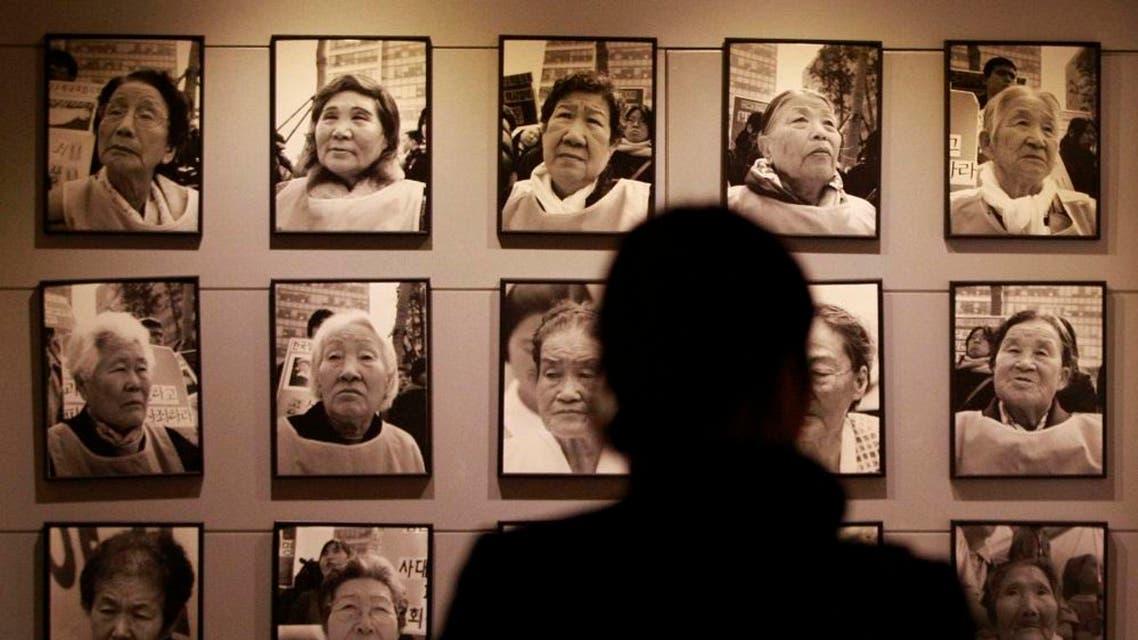 A visitor looks at portraits of late former "comfort women" who were forced to serve for the Japanese troops as a sexual slave during World War II, at the House of Sharing, a nursing home and museum for 10 former sex slaves, in Toechon, South Korea. (AP)