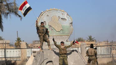 A member of the Iraqi security forces holds an Iraqi flag at a government complex in the city of Ramadi, December 28, 2015. (Reuters)