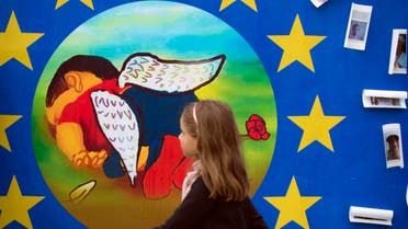 A painting of refugee Aylan Kurdi with angel wings and a rose on a board outside of EU headquarters in Brussels on Sunday, Sept. 13, 2015. (AP)