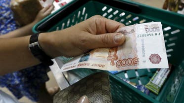A customer holds a Russian 5,000-rouble as she buys food at a grocery shop in the Siberian city of Krasnoyarsk, Russia, August 6, 2015. (Reuters)