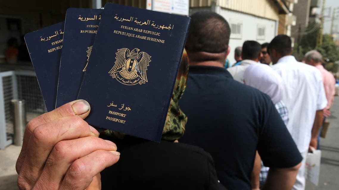 In this Friday, Sept. 11, 2015 photo, a Syrian man holds his family's passports as he lines up with other Syrians to apply for asylum visas, outside the German embassy, in Rabieh, north Beirut, Lebanon. (File photo: AP)
