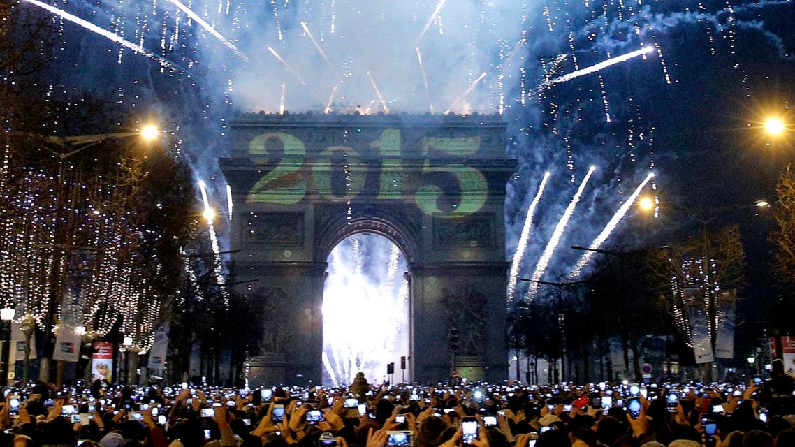 Revelers photograph fireworks over the Arc de Triomphe as they celebrate the New Year's Eve on the Champs Elysees avenue in Paris, France, Thursday, Jan. 1, 2015. (AP)