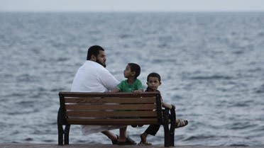 Illustrative photo: A man and his children sit on a bench next to the Red Sea in Jizan October 6, 2010. (Reuters)